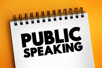 Public speaking - mean the act of speaking face to face to a live audience, text concept on notepad