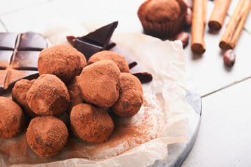 Chocolate truffles with cocoa powder in wooden dish on old cracked tile table background. Tasty sweet chocolate truffles candies. Valentine's Day and Mother's Day concept with copy space. Top view.