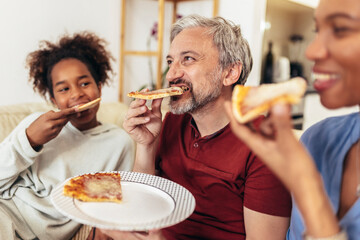 Happy family sharing pizza together at home