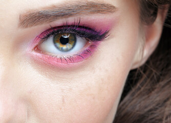 Fototapeta premium Closeup macro shot of human female eye with pink eyes shadows