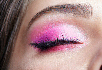 Naklejka premium Closeup macro shot of closed human female eye. Girl with perfect skin and pink eyes shadows