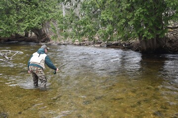 Fototapeta na wymiar An angler fishing on a river 