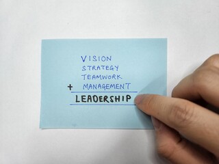 A sticky note showing the words "Vision, Strategy, Teamwork, Management, Leadership"