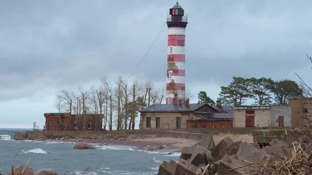 Spring, Autumn and Winter in the bay where the storm is raging. A striped Lighthouse on the shores of the northern raging sea. Scandinavian mood at the end of the world. Baltic sea coastline