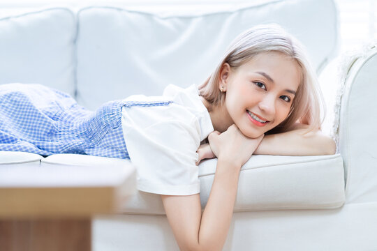 Portrait of young Asian girl lying on sofa at home