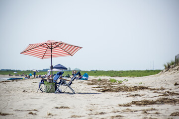 Red and White Striped Umbrella Shade Two Beach Blue Beach Chairs on a Beach in Delaware