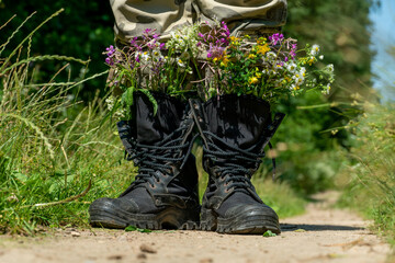 Black military boots with flowers. Concept - flowers instead of bullets and war. Ending the war in...