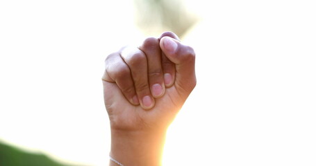 Black hand raised fist in air in political protest, close-up clench fist