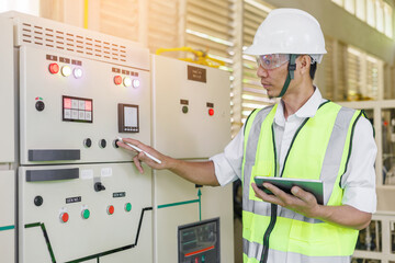 Electrical engineer holding tablet to inspecting the electrical system in a factory, energy concept.