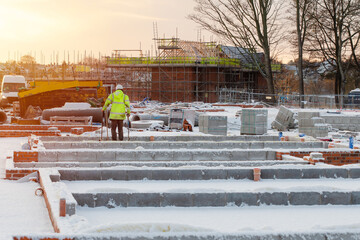 Construction worker on housing site in wintertime during construction of a new residential house