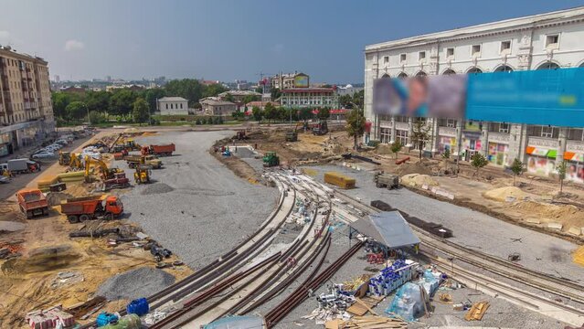 Laying of new tram rails on a city street. Repair works on the street aerial panoramic timelapse. Installation of new modern railway rails for trams. Reconstruction of tram tracks on intersection