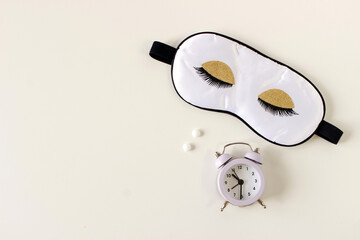 Flat lay composition with sleep eye mask, dream book and alarm clock on background. Healthy...
