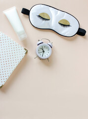 Flat lay composition with sleep eye mask, dream book and alarm clock on background. Healthy...