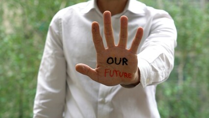 businessman hands with written in our hands is our future - protest and message against climate...