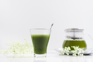 Un vaso de té verde matcha sobre una mesa blanca	