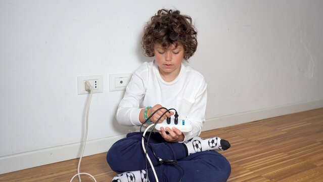 7-year-old child at home uses and plays with the electrical socket with the danger of getting shocked - domestic life in childhood 