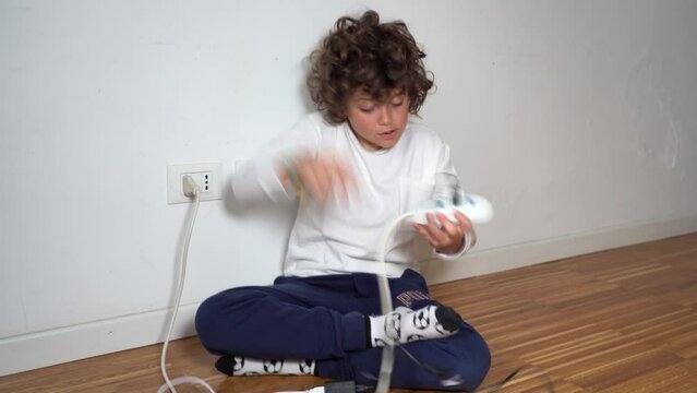 7-year-old child at home uses and plays with the electrical socket with the danger of getting shocked - domestic life in childhood 