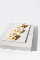 Tostadas de queso de cabra sobre mármol. Aperitivo sobre fondo claro	