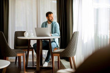 Young man using laptop and drink tea in the living room