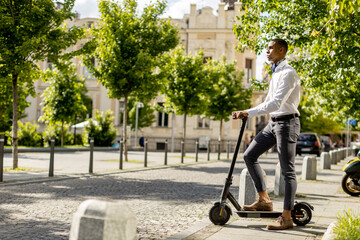 Young African American using electric scooter on a street © BGStock72