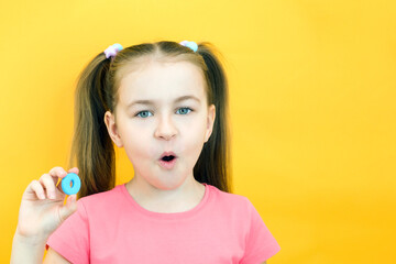 speech therapy. Toddler girl holding the letter O in her hands. Classes with a speech therapist. Girl on isolated yellow