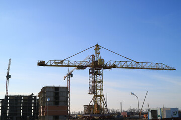Fototapeta na wymiar Tower cranes are working on the construction of a new house. Lifting crane.