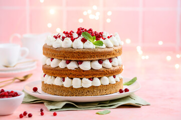 Festive spicy gingerbread cake with lingonberries or cranberries and cream cheese on a pink...