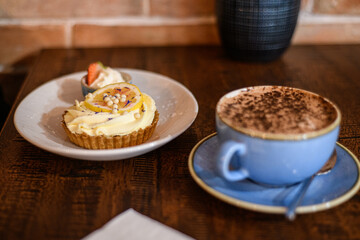 Overhead view of a chocolate and nut cookie with a hot chocolate on a table