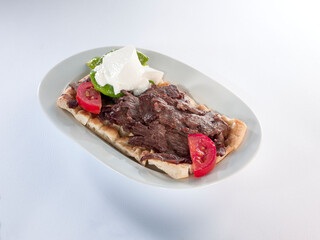 Turkish kebab and garnish on pita bread, Bursa İskender kebab