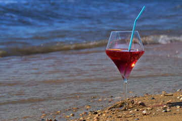 Wine glass with a cocktail by the sea.