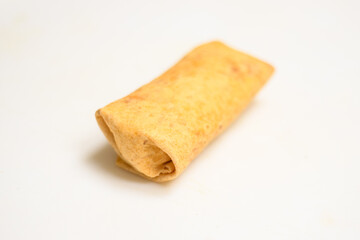 Close-Up of a person wearing disposable protective gloves preparing a tortilla wrap with chicken, cheese, onion and chili sauce