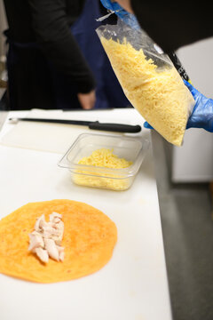 Close-Up of a person wearing disposable protective gloves making a wrap  in a kitchen.