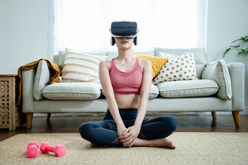 Asian female athletes in sportswear wearing virtual reality  to see an example of a yoga pose in...