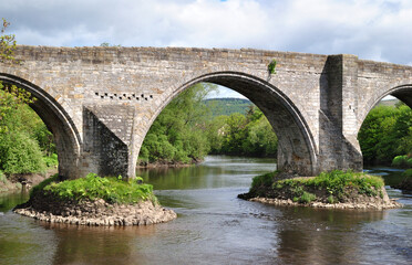 Fototapeta na wymiar View of Ancient Stone Bridge and River on Sunny Day 