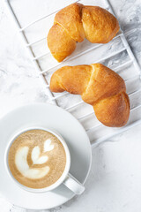 Morning coffee with croissant. Light breakfast. The atmosphere of an early calm morning.