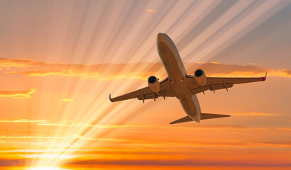 Naklejka na ściany i meble Airplane flying over tropical sea at sunset