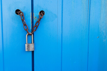 Lock on a blue door with a chain on the right there is a place for an - Powered by Adobe