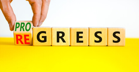 Regress or progress symbol. Businessman turns wooden cubes and changes the word Regress to...