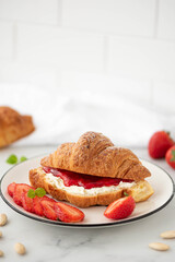 croissant with strawberry jam and cream cheese
