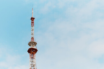 TV tower spire against a cloudy sky. Red and white contrasting colors.