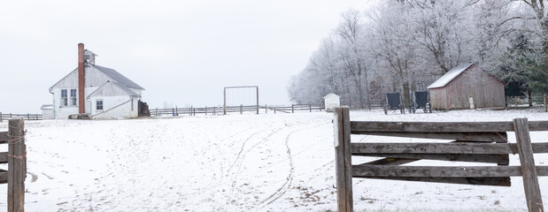 Amish Parochial School House and Yard Beside some Woods in the Winter with a Wooden Fence in the Foreground