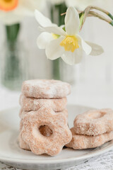 Stack of fresh Canestrelli, italian shortbread cookies. Flower shaped cookies with the hole in the centre on a blurred background.