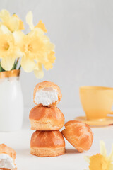 Stack of small round eclairs or profiteroles for tasty breakfast. Traditional french eclairs.