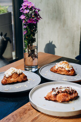 Croissant with jam, croissant with chocolate, croissant with vanilla cream on a plate. Delicious breakfast and dessert.