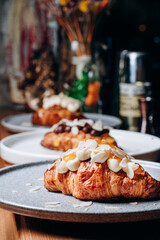 Croissant with jam, croissant with chocolate, croissant with vanilla cream on a plate. Delicious breakfast and dessert.