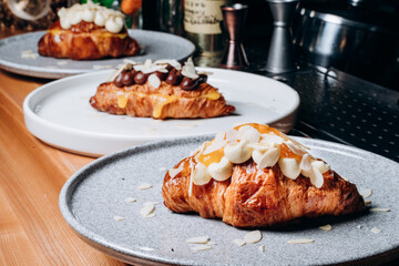 Croissant with jam, croissant with chocolate, croissant with vanilla cream on a plate. Delicious breakfast and dessert.