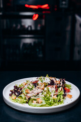 Caesar salad with chicken, Parmesan and wheat croutons on a vintage grey background. Light diet dinner.