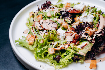 Caesar salad with chicken, Parmesan and wheat croutons on a vintage grey background. Light diet dinner.