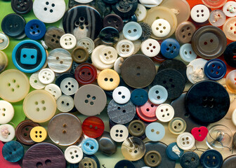 Close up buttons sewing, macro colorful image. Collection of assorted spare clothes buttons vintage. Sewing tools. Color buttons frame on fabric texture background wallpaper