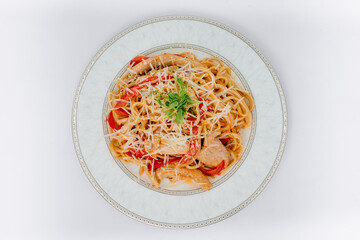 asian udon noodles with chicken and vegetables on a plate on a white background